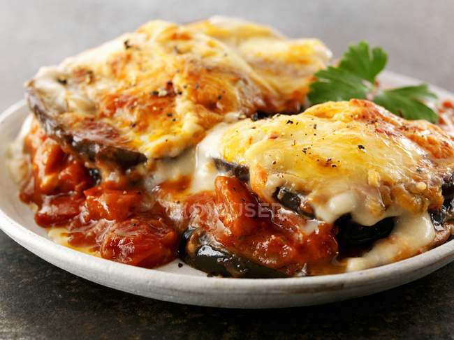 Gratinated aubergines with tomato sauce  on white plate — Stock Photo