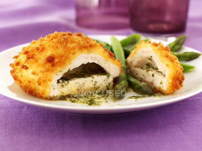 Kiev di pollo con burro all'aglio, erbe aromatiche e asparagi su piatto bianco — Foto stock