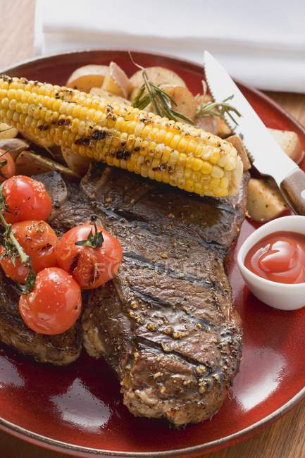 Gegrilltes Steak auf rotem Teller — Stockfoto