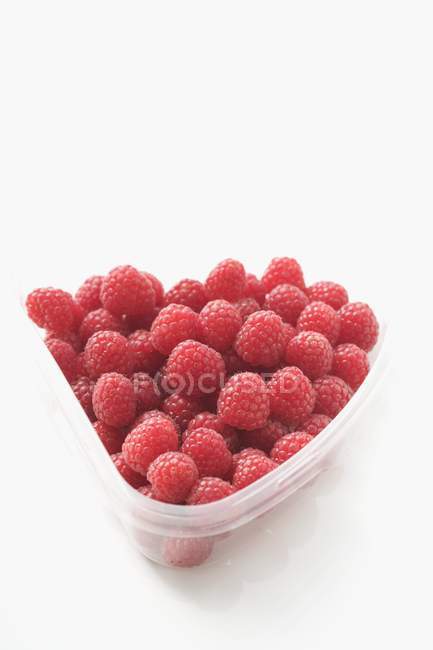 Raspberries in plastic container — Stock Photo
