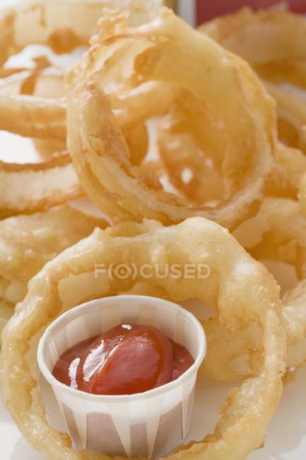 Anillos de cebolla frita con salsa de tomate - foto de stock