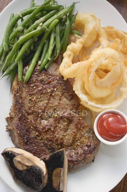 Rib-eye steak with beans — Stock Photo