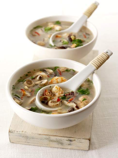 Vue rapprochée de la soupe aux crevettes aux champignons et aux herbes dans des bols — Photo de stock