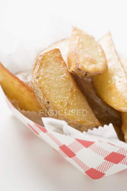 Fatias de batata fritas em recipiente de papelão — Fotografia de Stock
