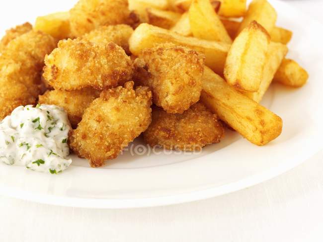 Vue rapprochée des langoustines panées avec frites et sauce — Photo de stock