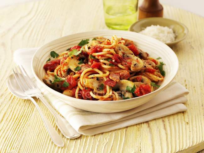 Espaguetis con tomates y tocino - foto de stock