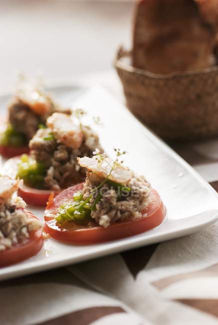 Salade de tomates au thon sur assiette blanche — Photo de stock