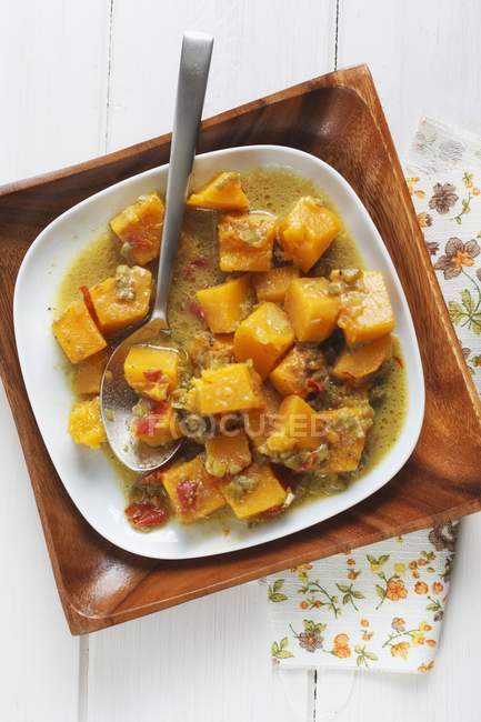 Vue de dessus du curry de citrouille avec une cuillère dans des bols — Photo de stock