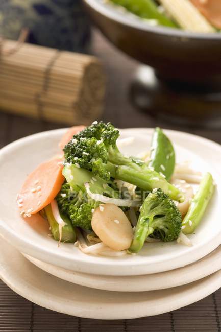 Placa de verduras con semillas de sésamo en plato blanco - foto de stock