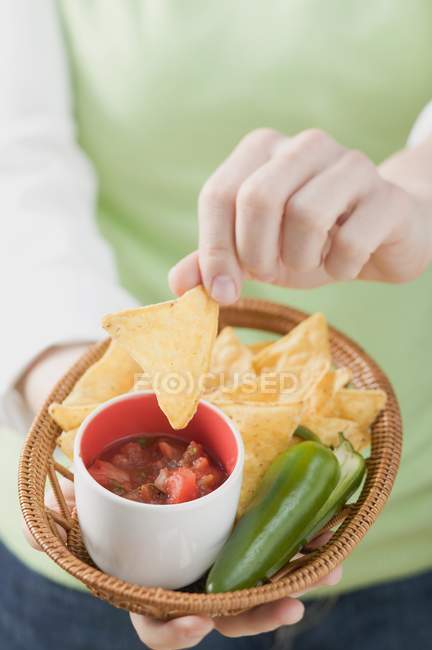 Donna che tiene un cesto di nachos — Foto stock