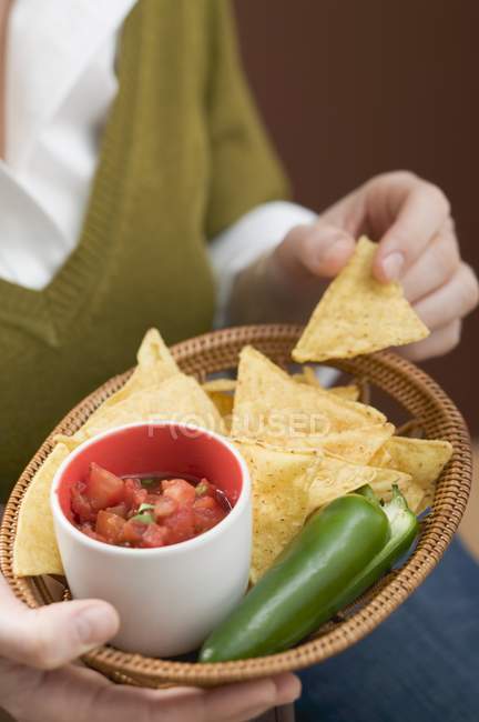 Femme tenant panier de nachos — Photo de stock