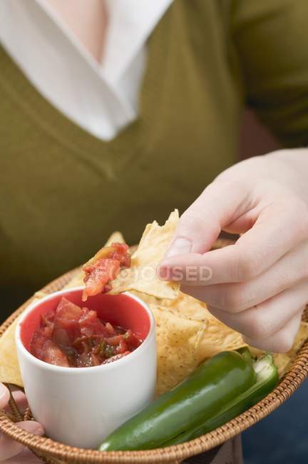 Femme trempant Nacho dans la salsa de tomate — Photo de stock