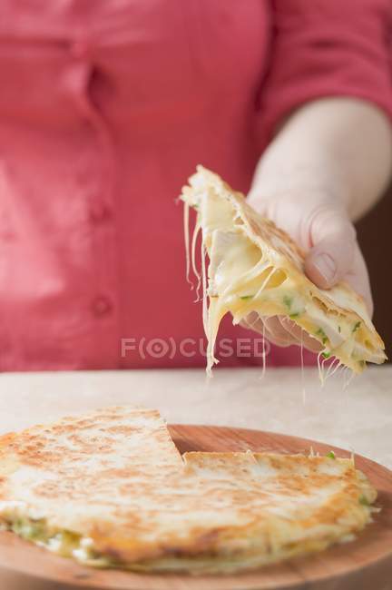 Prise de main morceau de quesadilla — Photo de stock