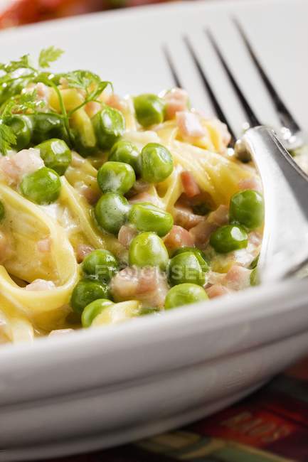 Pasta with sliced ham and peas — Stock Photo