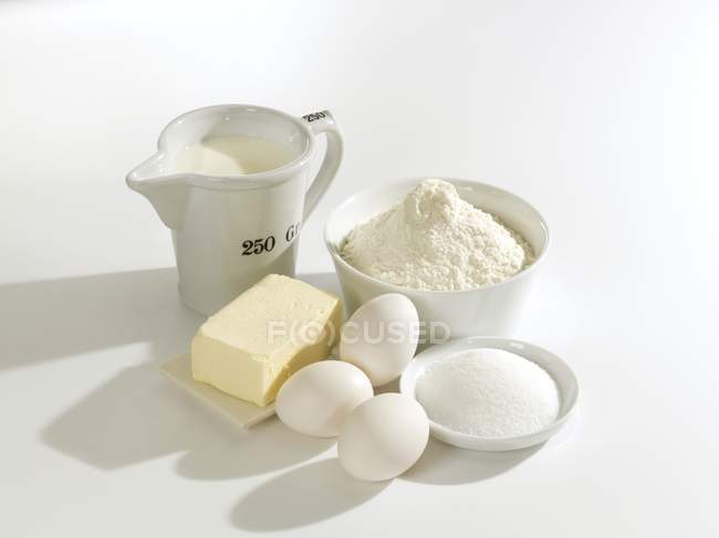 Elevated view of butter with eggs, sugar, flour and milk — Stock Photo