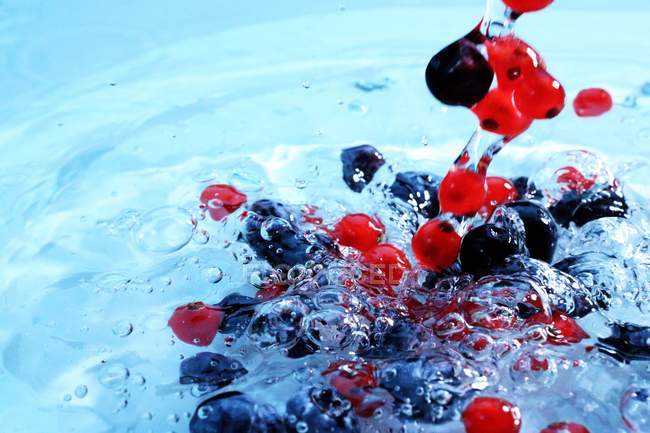 Berries falling in water — Stock Photo
