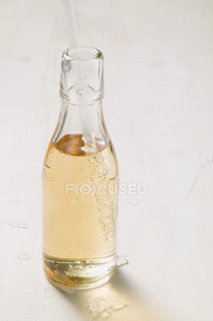 Closeup view of fizzy drink in bottle with straw — Stock Photo
