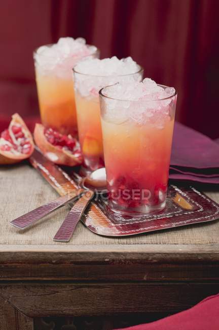 Vista close-up de três bebidas frutadas com laranja e romã — Fotografia de Stock