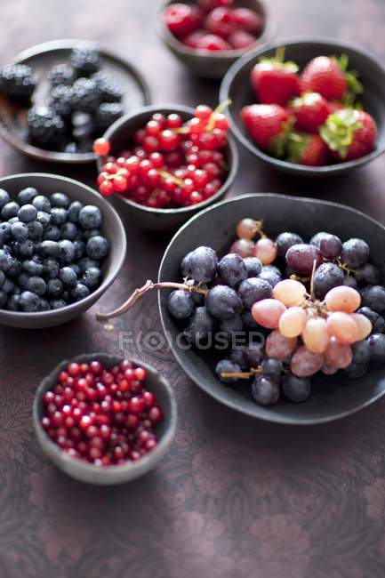 Berries and grapes in bowls — Stock Photo