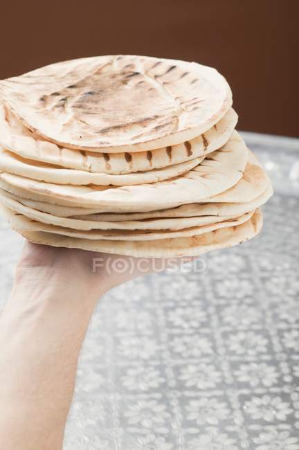Hand holding grilled flatbreads — Stock Photo