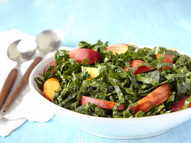 Schüssel Grünkohl-Pfirsich-Salat auf weißem Teller — Stockfoto