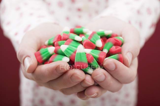 Mani femminili in possesso di mais caramelle — Foto stock