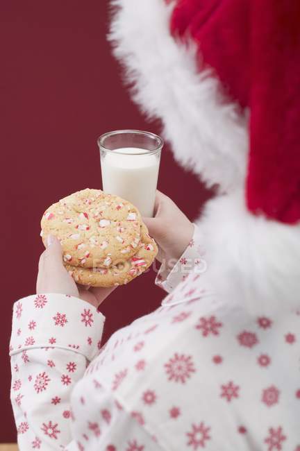 Woman in Christmas hat holding cookies — Stock Photo