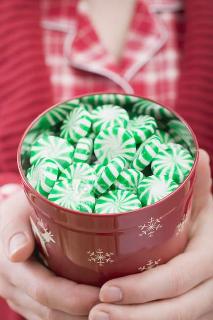 Woman holding tin of peppermints — Stock Photo