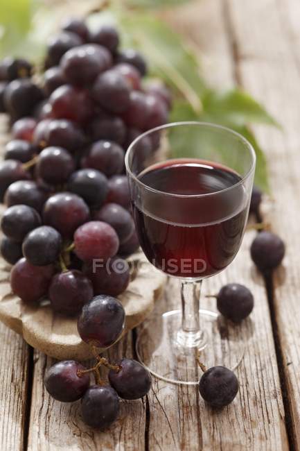 Copa de vino tinto y uvas - foto de stock