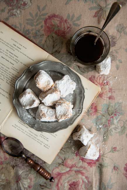 Top view of Turkish Delight on plate and opened book with glass of drink — Stock Photo