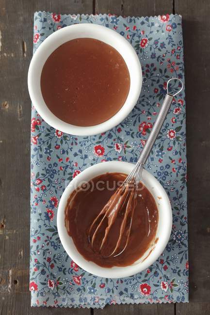 Vista superior de chocolate Blancmange com batedor em duas taças em toalha — Fotografia de Stock