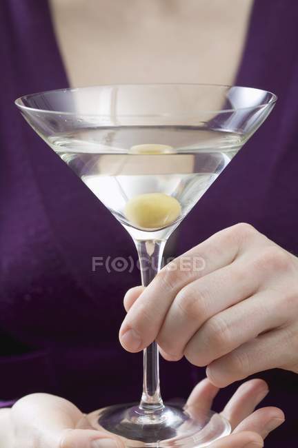 Женщина держит мартини с оливками — стоковое фото
