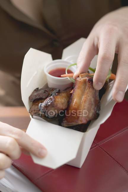 Mulher comendo costelas de porco envidraçadas — Fotografia de Stock