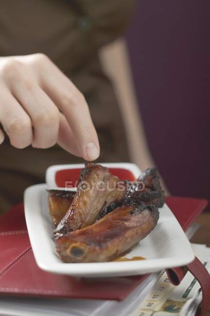 Frau isst glasierte Schweinerippchen — Stockfoto