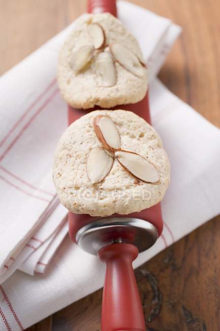 Almond biscuits on rolling pin — Stock Photo