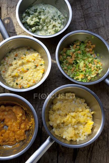 A selection of accompaniments in pots over wooden surface — Stock Photo