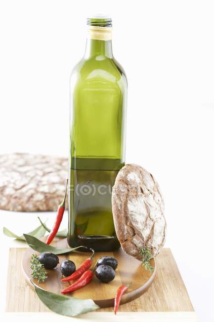 Bouteille d'huile d'olive aux olives et piments — Photo de stock