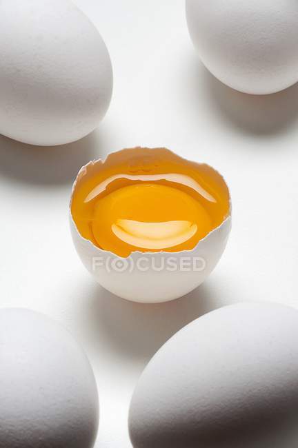Whole and cracked eggs — Stock Photo