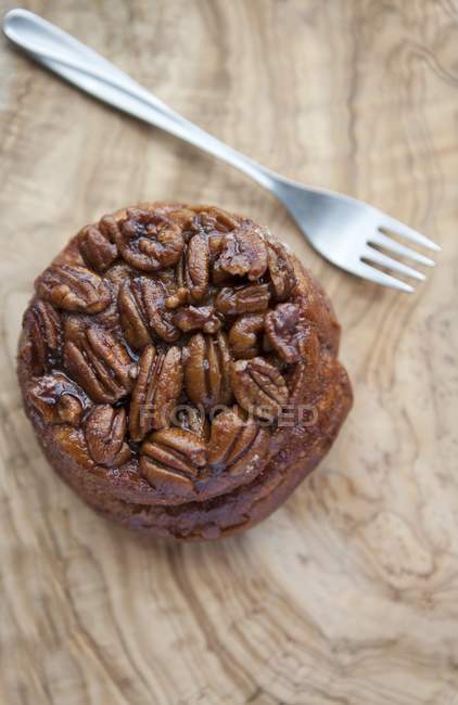 Stick bun topped with pecan nuts — Stock Photo
