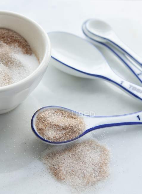 Коричный сахар в миске и на ложке — стоковое фото