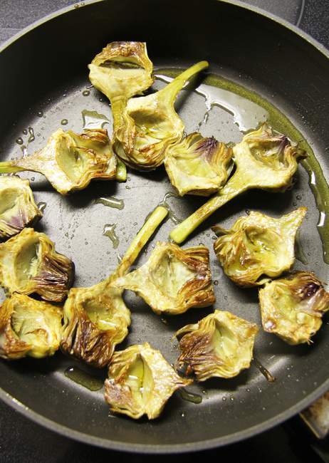 Fried artichoke hearts in a pan — Stock Photo