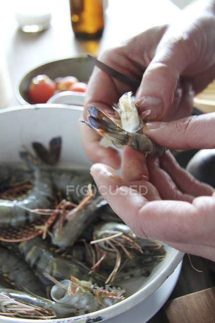 Mãos humanas descascando camarões frescos — Fotografia de Stock