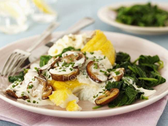 Haddock with mushrooms and spinach — Stock Photo