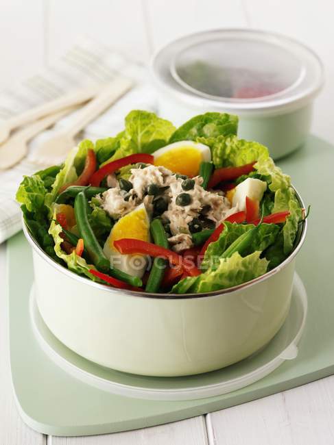 Salad Nioise in a lunchbox over wooden surface — Stock Photo