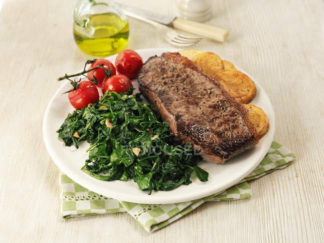 Beef steak with spinach — Stock Photo