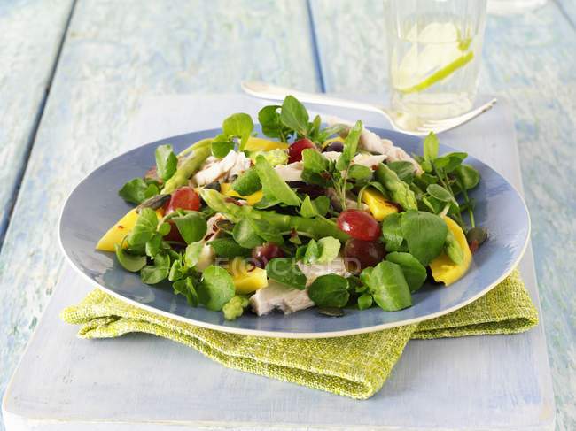 Closeup view of watercress salad with mango on plate — Stock Photo