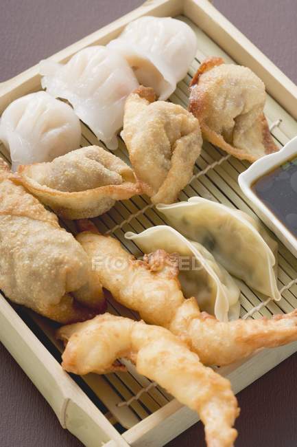 Closeup view of Asian appetizers with sauce on platter — Stock Photo