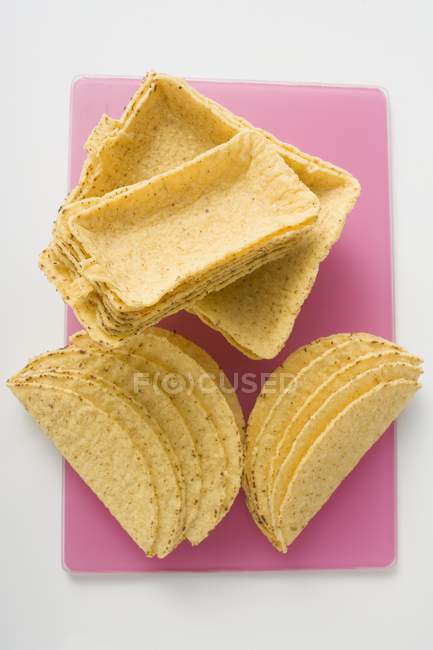 Vista superior close-up de conchas Taco sortidas na tábua de corte rosa — Fotografia de Stock
