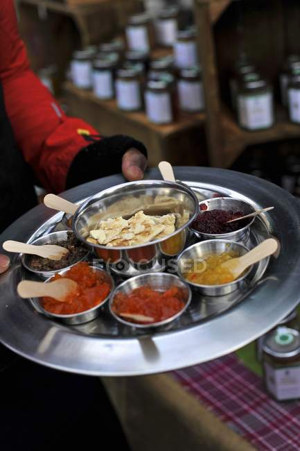 Elevated cropped view of person holding tray with Caribbean dips — Stock Photo