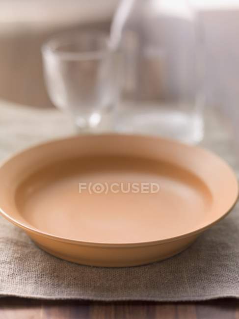 Nahaufnahme eines leeren Tellers auf Leinentuch — Stockfoto